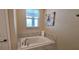 Cozy bathroom with a white tiled tub and marble accents at 1201 Challenge Dr, Davenport, FL 33896