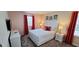 Cozy bedroom with a plush queen-sized bed, red curtains, and soft lighting at 1201 Challenge Dr, Davenport, FL 33896