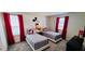 This Disney-themed bedroom features two twin beds with red curtains that frame the windows at 1201 Challenge Dr, Davenport, FL 33896