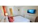 Relax in the primary bedroom with a comfortable bed, dresser, and TV for relaxing after a long day at 1201 Challenge Dr, Davenport, FL 33896