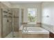 Beautiful bathroom featuring a soaking tub, glass-enclosed shower, and a large window at 1269 Long Cove Loop # 1269, Davenport, FL 33896