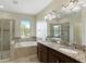 A Luxurious bathroom with a soaking tub, double vanity, and glass-enclosed shower at 1269 Long Cove Loop # 1269, Davenport, FL 33896
