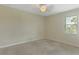 Well-lit bedroom with a ceiling fan, neutral walls, carpet, and a bright window with neighborhood view at 1269 Long Cove Loop # 1269, Davenport, FL 33896