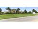 A view of the Oasis Clubhouse featuring lush green landscaping and palm trees at 1269 Long Cove Loop # 1269, Davenport, FL 33896