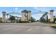 Ornate community entrance showcasing decorative towers, lush landscaping, and a wide street at 1269 Long Cove Loop # 1269, Davenport, FL 33896