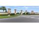 Community entrance featuring stone monuments with decorative lettering, landscaping, and crosswalk at 1269 Long Cove Loop # 1269, Davenport, FL 33896
