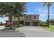 Beautiful two-story home with a well-manicured lawn, mature trees, and brick paved driveway at 1269 Long Cove Loop # 1269, Davenport, FL 33896