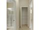 Hallway with neutral walls featuring a linen closet and bathroom with glass enclosed shower at 1269 Long Cove Loop # 1269, Davenport, FL 33896