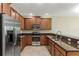 Spacious kitchen featuring stainless steel appliances, granite countertops, and wood cabinets at 1269 Long Cove Loop # 1269, Davenport, FL 33896