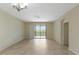 Living area featuring neutral tile floors, a modern chandelier, and sliding glass doors to the lanai at 1269 Long Cove Loop # 1269, Davenport, FL 33896