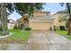 Two-story home with a beige exterior, well-manicured lawn, and a two-car garage at 1400 Holly Glen Run, Apopka, FL 32703