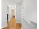 Hallway with wood floors, white walls, and doorways leading to various rooms at 1400 Holly Glen Run, Apopka, FL 32703