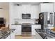 Kitchen showcasing white cabinets, black granite countertops, and stainless steel appliances at 1400 Holly Glen Run, Apopka, FL 32703