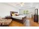Inviting primary bedroom featuring a tray ceiling, wood floors, and large window at 1400 Holly Glen Run, Apopka, FL 32703