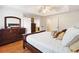 Comfortable primary bedroom featuring a tray ceiling, wood floors, and a large dresser at 1400 Holly Glen Run, Apopka, FL 32703