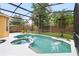 Beautiful screened-in pool and spa with lush landscaping creating a private backyard oasis at 1400 Holly Glen Run, Apopka, FL 32703