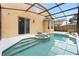 View of screened-in pool and spa with a covered patio and tan exterior at 1400 Holly Glen Run, Apopka, FL 32703