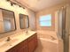 Bathroom with double sinks, framed mirrors and a large tub at 14715 Buckingham Gate Ct, Orlando, FL 32828