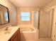 Bathroom featuring tub shower combo with glass doors and a window at 14715 Buckingham Gate Ct, Orlando, FL 32828