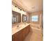 Bathroom with double sinks, framed mirrors and a large tub at 14715 Buckingham Gate Ct, Orlando, FL 32828