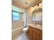 Bathroom with tiled floor, a tub and shower combination, vanity, and a window at 14715 Buckingham Gate Ct, Orlando, FL 32828