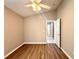 Bedroom with wood-look floors, ceiling fan, and access to a hall and bathroom at 14715 Buckingham Gate Ct, Orlando, FL 32828