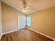 Bedroom showcasing wood-look flooring, ceiling fan, closet, and natural light from the window at 14715 Buckingham Gate Ct, Orlando, FL 32828