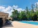 Community pool surrounded by lounge chairs and lush greenery on a sunny day in Stone Brook at 14715 Buckingham Gate Ct, Orlando, FL 32828