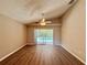 Bright living room featuring wood floors, ceiling fan and sliding glass doors to the outdoor pool area at 14715 Buckingham Gate Ct, Orlando, FL 32828