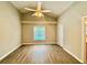 Spacious primary bedroom features a ceiling fan, wood floors, and a large window providing natural light at 14715 Buckingham Gate Ct, Orlando, FL 32828