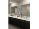 Spacious bathroom featuring double sinks, dark cabinetry and a well-lit mirror at 1635 Wynford Cir, Tavares, FL 32778