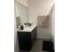 Modern bathroom featuring a dark vanity, large mirror, and fresh white walls, offering a clean and sleek aesthetic at 1635 Wynford Cir, Tavares, FL 32778