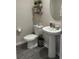 Well-lit powder room featuring a pedestal sink, complemented by decorative shelves at 1635 Wynford Cir, Tavares, FL 32778