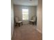 Cozy bedroom featuring neutral carpet and chairs, bathed in natural light from a bright window at 1635 Wynford Cir, Tavares, FL 32778