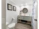 Clean, updated bathroom with gray vanity, new fixtures, decorative art, and palm-themed shower curtain at 164 Royal Palm Dr, Leesburg, FL 34748
