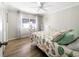 Light-filled bedroom with wood floors, ceiling fan, and seashell-themed bedspread; natural light shining through at 164 Royal Palm Dr, Leesburg, FL 34748