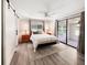 Bright bedroom with a ceiling fan, wood floors, and sliding glass doors to the outdoor patio at 164 Royal Palm Dr, Leesburg, FL 34748