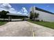 Driveway leading to a modern building with attractive landscaping at 164 Royal Palm Dr, Leesburg, FL 34748