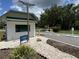 View of the Hawthorne community entrance with a guard house, gate, signage, and manicured landscaping at 164 Royal Palm Dr, Leesburg, FL 34748