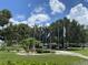 Community space with flag poles, lush landscaping, and well-maintained walkways at 164 Royal Palm Dr, Leesburg, FL 34748