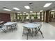A bright community room with tables and chairs under fluorescent lighting and large windows overlooking the grounds at 164 Royal Palm Dr, Leesburg, FL 34748