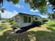 Well-maintained home exterior featuring manicured landscaping and window awnings at 164 Royal Palm Dr, Leesburg, FL 34748