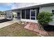 Home featuring a screened porch, carport, and walkway amidst landscaped surroundings at 164 Royal Palm Dr, Leesburg, FL 34748