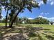 Picturesque community grounds with mossy trees and open green space under a bright blue sky at 164 Royal Palm Dr, Leesburg, FL 34748