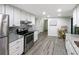Updated kitchen with white cabinets, gray countertop, stainless steel appliances, and decorative backsplash at 164 Royal Palm Dr, Leesburg, FL 34748