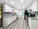 Renovated kitchen features stylish backsplash, modern appliances, gray countertops, and ample cabinet space at 164 Royal Palm Dr, Leesburg, FL 34748