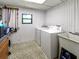 Functional laundry room with washer, dryer, utility sink, and ample storage space for household needs at 164 Royal Palm Dr, Leesburg, FL 34748