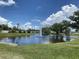 Scenic pond with a fountain in the middle and golf cart in distance creating a picturesque view at 164 Royal Palm Dr, Leesburg, FL 34748
