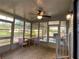Enclosed porch offering sunlight, a ceiling fan, and tiled flooring for relaxed outdoor living at 164 Royal Palm Dr, Leesburg, FL 34748