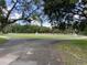 A softball field sits underneath shaded trees surrounded by greenery in this scenic real estate community at 164 Royal Palm Dr, Leesburg, FL 34748